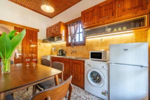 a kitchen with a white refrigerator and a table with chairs at Princess House in Sidari +18 photos