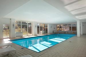a large swimming pool with blue water in a house at Fw Moonlight mit Sauna, Schwimmbad in Schönwald