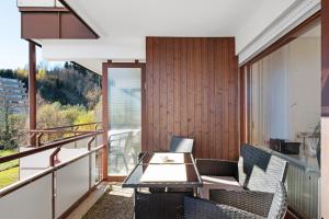a balcony with a table and chairs and a view at Fw Moonlight mit Sauna, Schwimmbad in Schönwald