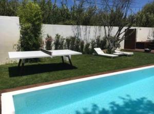 a white bench next to a swimming pool at Casa da Granja in Sobral de Monte Agraço