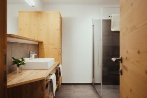a bathroom with a sink and a shower at Chalet La Flüta Arnica in La Valle