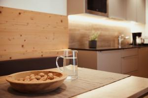 a bowl of nuts on a table with a glass at Chalet La Flüta Arnica in La Valle