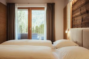 two beds in a bedroom with a window at Chalet La Flüta Arnica in La Valle