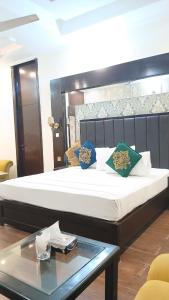 a bed in a room with a glass table at Hotel Royal One in Multan