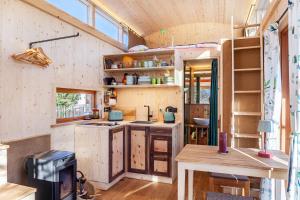 a kitchen in a tiny house with wooden cabinets at Loft Süd in Unterammergau +27 photos