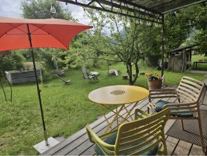 a patio with a table and chairs and an umbrella at Loft Süd in Unterammergau