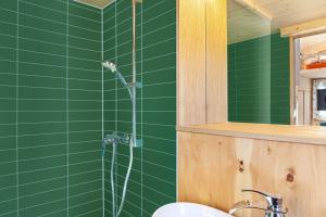 a green bathroom with a shower and a sink at Loft Süd in Unterammergau