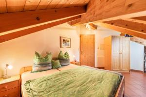 a bedroom with a bed with green sheets and wooden ceilings at Weingut Lieselehof Apt Panorama in Caldaro