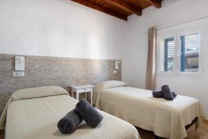a room with two beds with towels on them at Villa Sueños Zenoneisabel in Caleta de Sebo