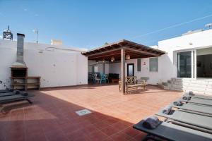 a large patio with a fireplace on a white building at Villa Sueños Zenoneisabel in Caleta de Sebo