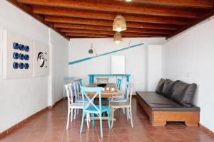 a dining room with a table and chairs and a couch at Villa Sueños Zenoneisabel in Caleta de Sebo