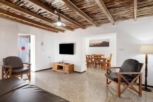 a living room with a tv and a table and chairs at Villa Sueños Zenoneisabel in Caleta de Sebo