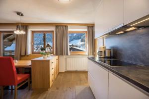 a kitchen with a counter top and a table with a tableablish at Rosalpina Apt 2 in San Vigilio Di Marebbe
