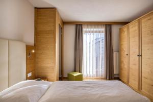 a bedroom with a large bed and a window at Rosalpina Apt 2 in San Vigilio Di Marebbe