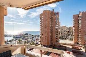 a balcony with a view of the ocean and buildings at Sunny studio with seaview in Fuengirola