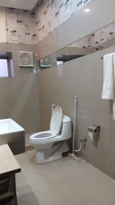 a white bathroom with a toilet and a sink at Hotel Royal One in Multan +17 photos