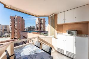 a balcony with a table and a kitchen with a view at Sunny studio with seaview in Fuengirola