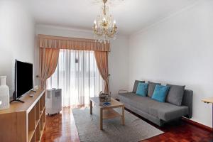 a living room with a couch and a tv at Casa Imaginário Com Serenidade in Caldas da Rainha
