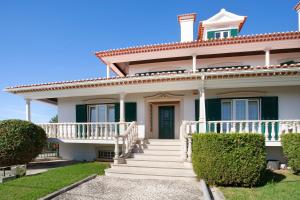 a white house with a porch and stairs at Casa Imaginário Com Serenidade in Caldas da Rainha