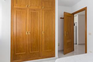 a wooden cabinet in a bedroom with a mirror at Las Alondras in Gandía
