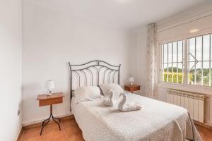 a bedroom with a bed with two swans on it at Can Fogars in Fogás de Tordera +23 photos