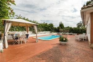a patio with a pool and a gazebo at Can Fogars in Fogás de Tordera
