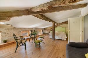 a living room with a bed and chairs in a room at Chambres D'hôtes - Le Marlas in Rieucros