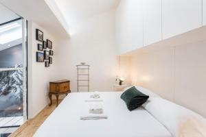 a white bedroom with a large bed and a window at Mandello amorevole dimora in Lecco in Lecco