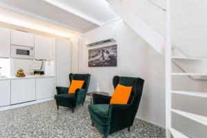 a living room with two chairs and a table at Mandello amorevole dimora in Lecco in Lecco