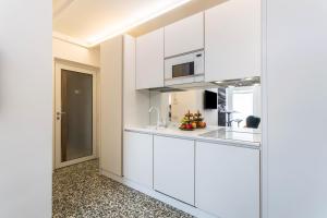 a kitchen with white cabinets and a microwave at Mandello amorevole dimora in Lecco in Lecco +12 photos