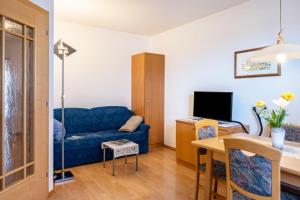 a living room with a blue couch and a table at Valtlhof - Apt 1 in Cornaiano