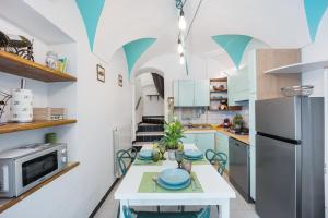 a kitchen with a table and a refrigerator at Domus Regina Elena in Sanremo