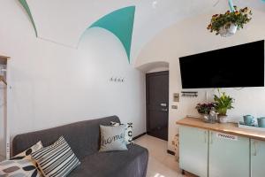 a living room with a couch and a flat screen tv at Domus Regina Elena in Sanremo