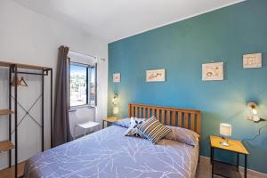 a bedroom with a bed and a blue wall at Domus Regina Elena in Sanremo