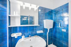 a blue tiled bathroom with a toilet and a sink at Domus Regina Elena in Sanremo +15 photos