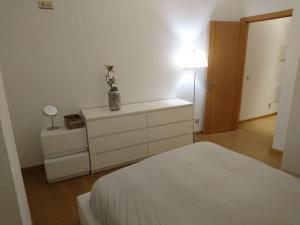 a bedroom with a bed and a dresser and a lamp at Faro City Center Apartment I in Faro
