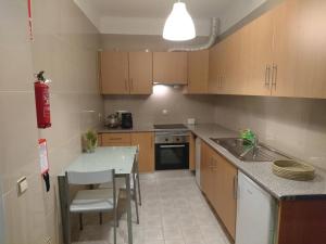a kitchen with a table and a sink and a counter at Faro City Center Apartment I in Faro