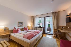 a bedroom with a bed and a large window at Ferienwohnung Förchensee in Ruhpolding