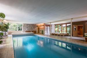 a large swimming pool with blue water in a house at Ferienwohnung Förchensee in Ruhpolding