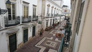 an empty alley with buildings and a tiled floor at Faro City Center Apartment I in Faro