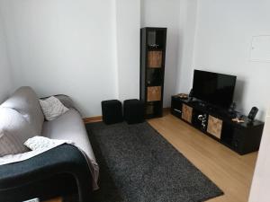 a living room with a couch and a flat screen tv at Faro City Center Apartment I in Faro