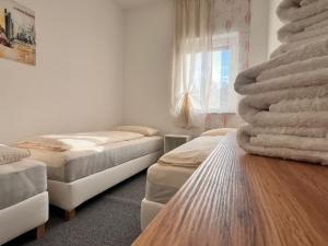 a room with two beds and a wooden table at Dreams Lodge in Koetz 