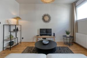 a living room with a couch and a table at Appartement Le Dauphin in Pornichet +3 photos