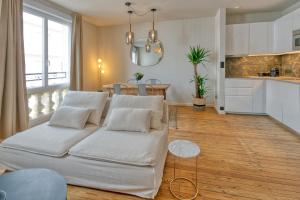 a living room with a white couch and a kitchen at Appartement Le Dauphin in Pornichet
