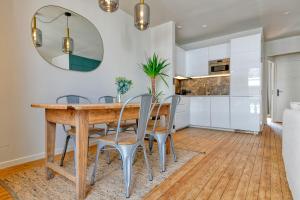a kitchen and dining room with a wooden table and chairs at Appartement Le Dauphin in Pornichet