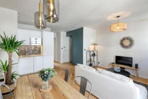 a living room with a white couch and a table at Appartement Le Dauphin in Pornichet