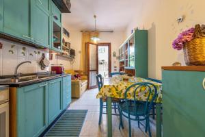 a kitchen with blue cabinets and a table with chairs at Villetta Lelu' in Villasimius