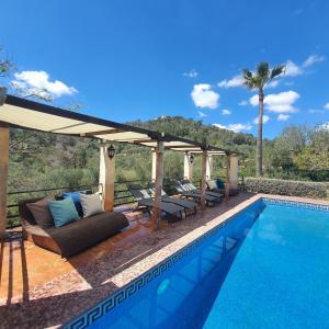 a swimming pool with a couch and a pergola at Es Forn in Petra