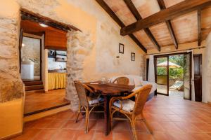 a dining room with a wooden table and chairs at Es Forn in Petra