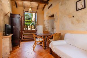 a room with a table and a bed and a television at Es Forn in Petra